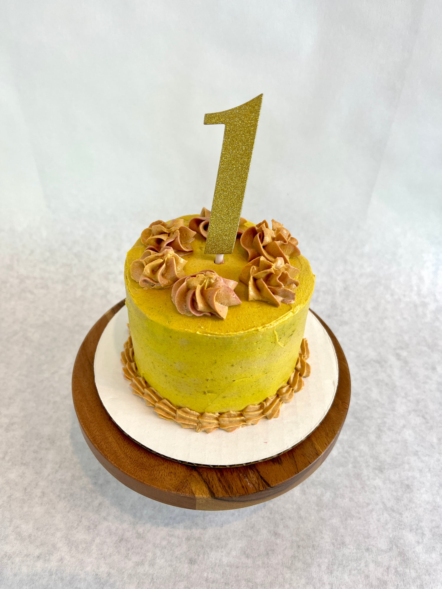 Custom dog birthday cake with yellow and orange icing. Includes gold glitter number one cake topper.