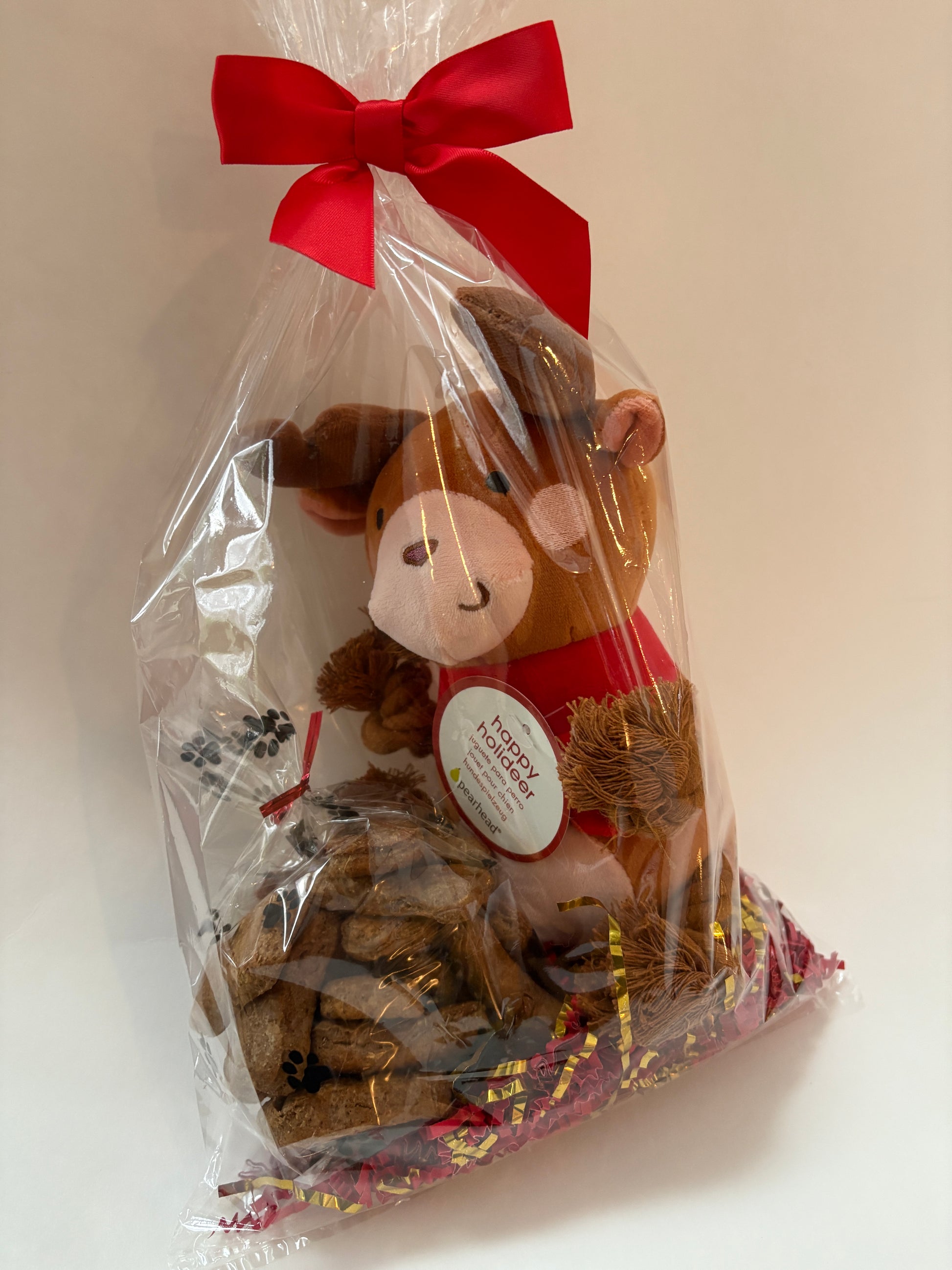 Plush reindeer toy with a red bow and gift bag on a white background