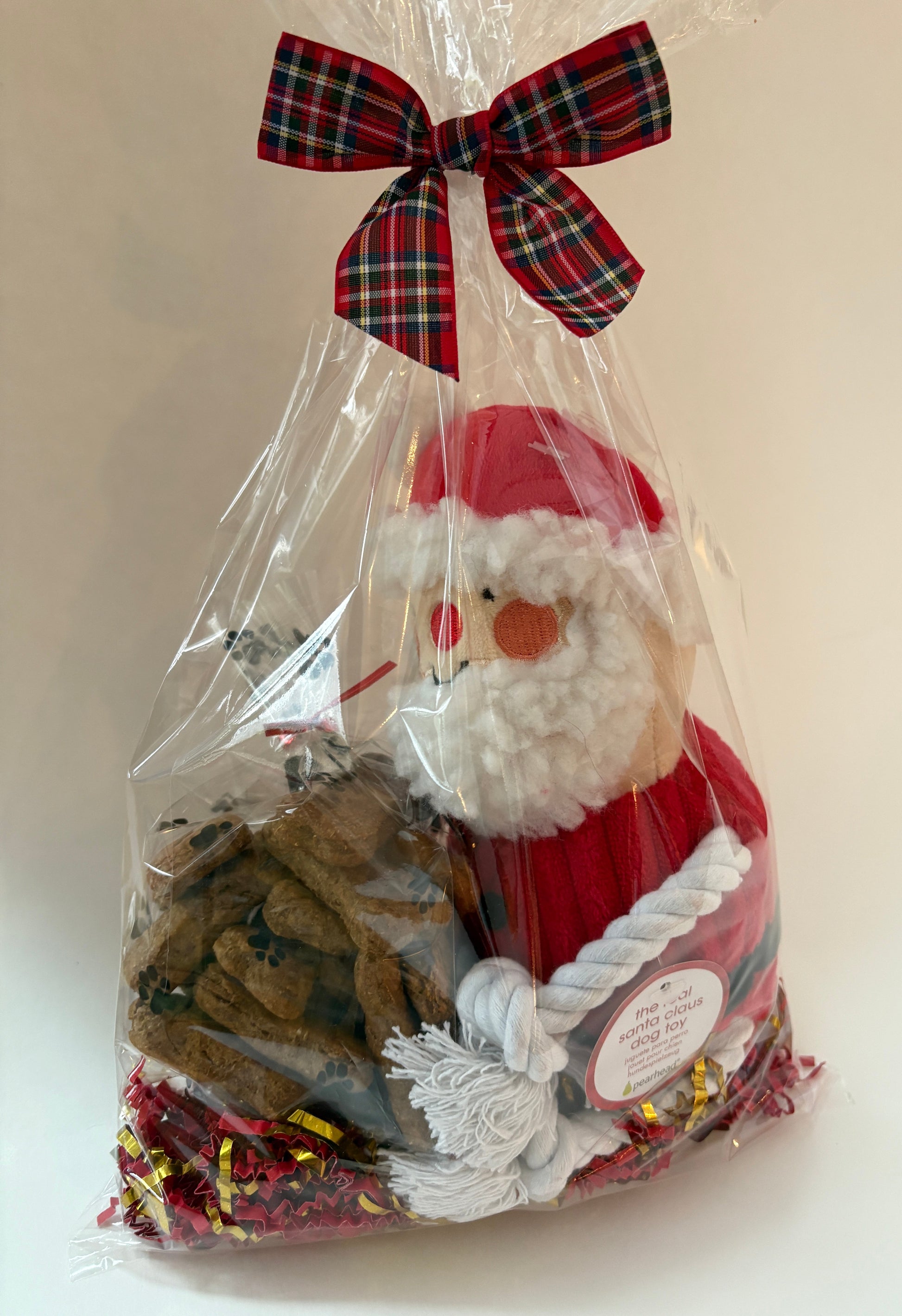 Christmas-themed gift bag with Santa Claus design and plaid bow on a white background