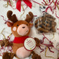 Plush reindeer toy, dog treats, and decorative ribbons on a white background