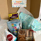Happy Birthday Box featuring blue dog birthday slice toy, birthday bandana in blue, Belle's Barkery Barkcuterie Box, and birthday hat